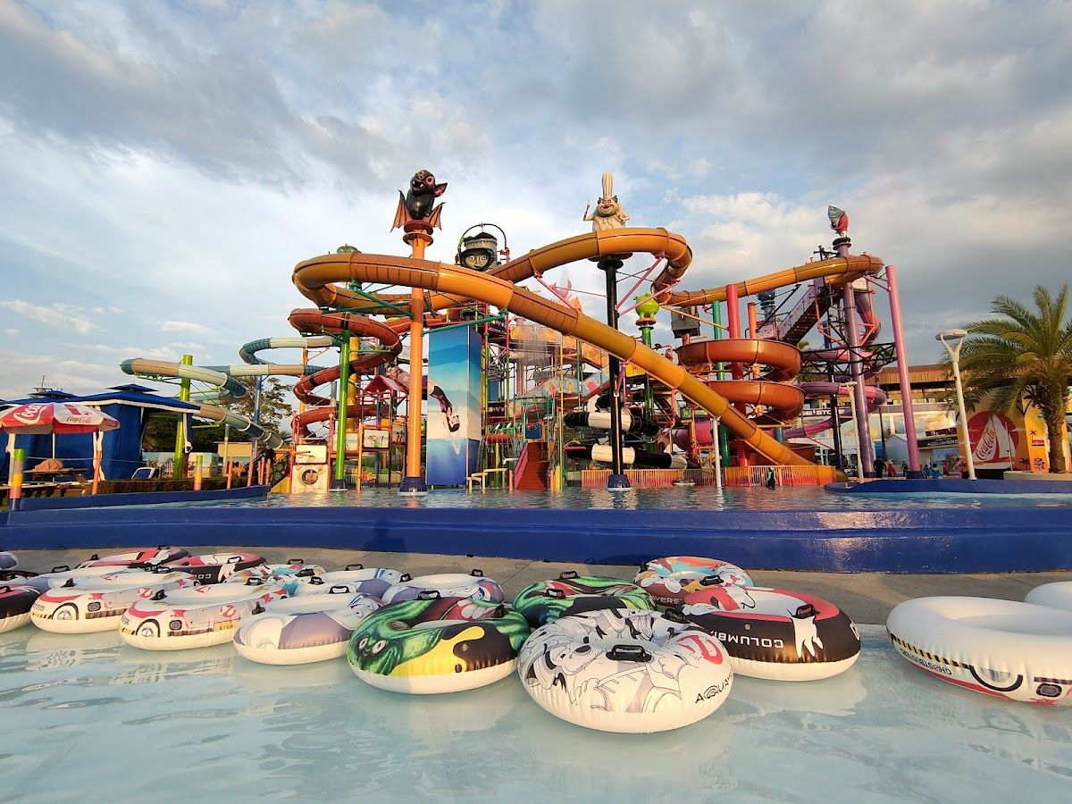 Aerial view of Ramayana Water Park near Pattaya showing multiple large water slides with a lake and hills in the background