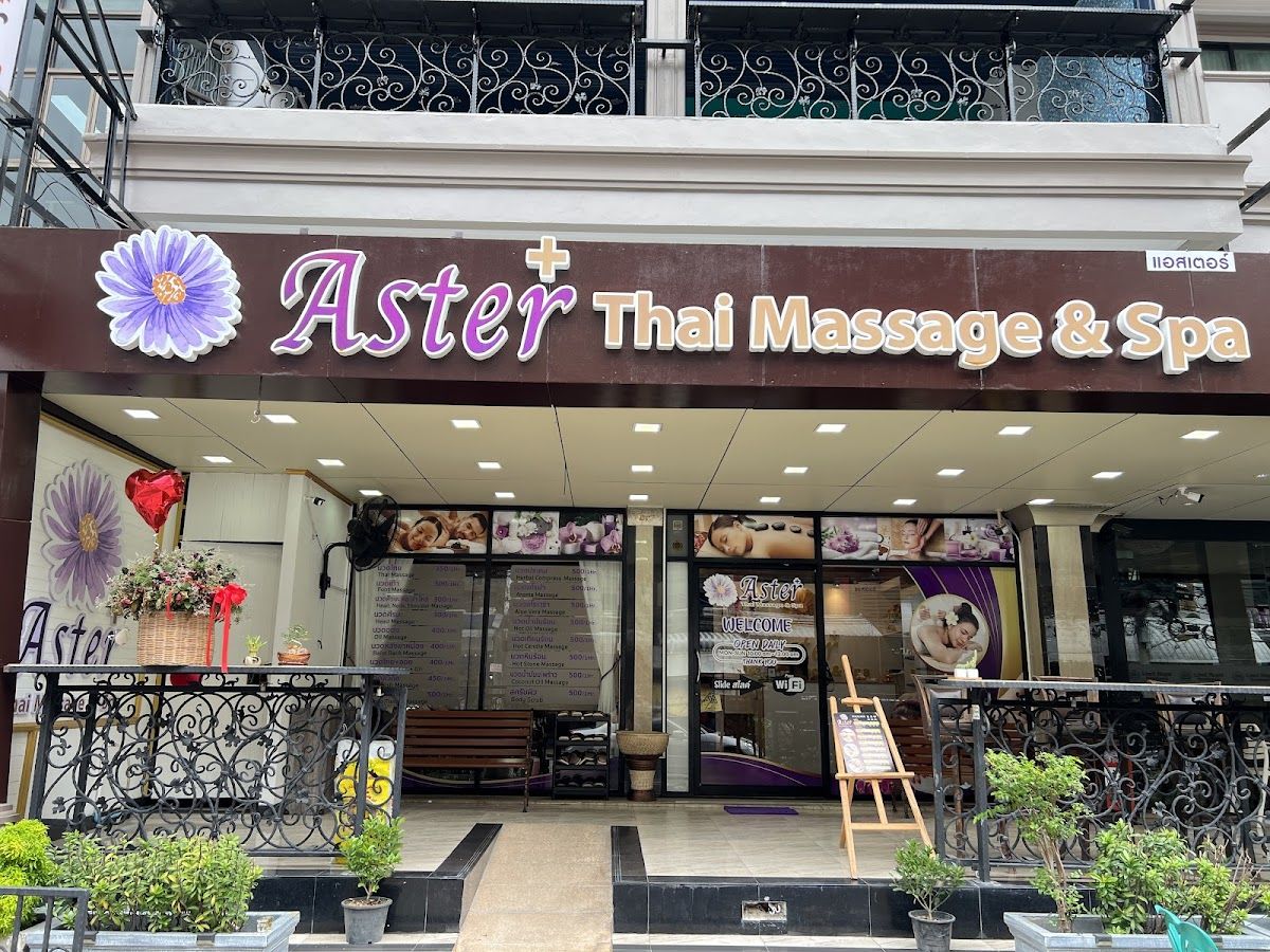Foot reflexology session in progress at a Pattaya massage parlour with therapists in red uniforms attending to reclining guests