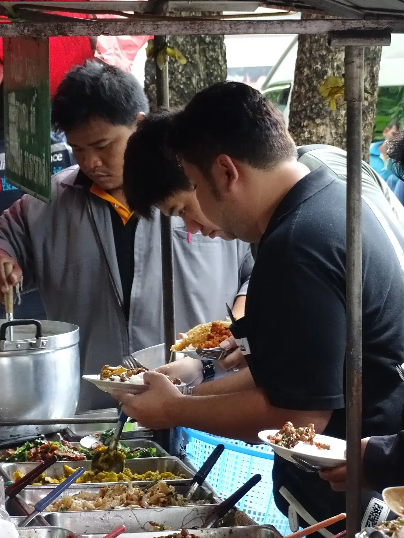 A cook working a wok at a Thai street-food stall