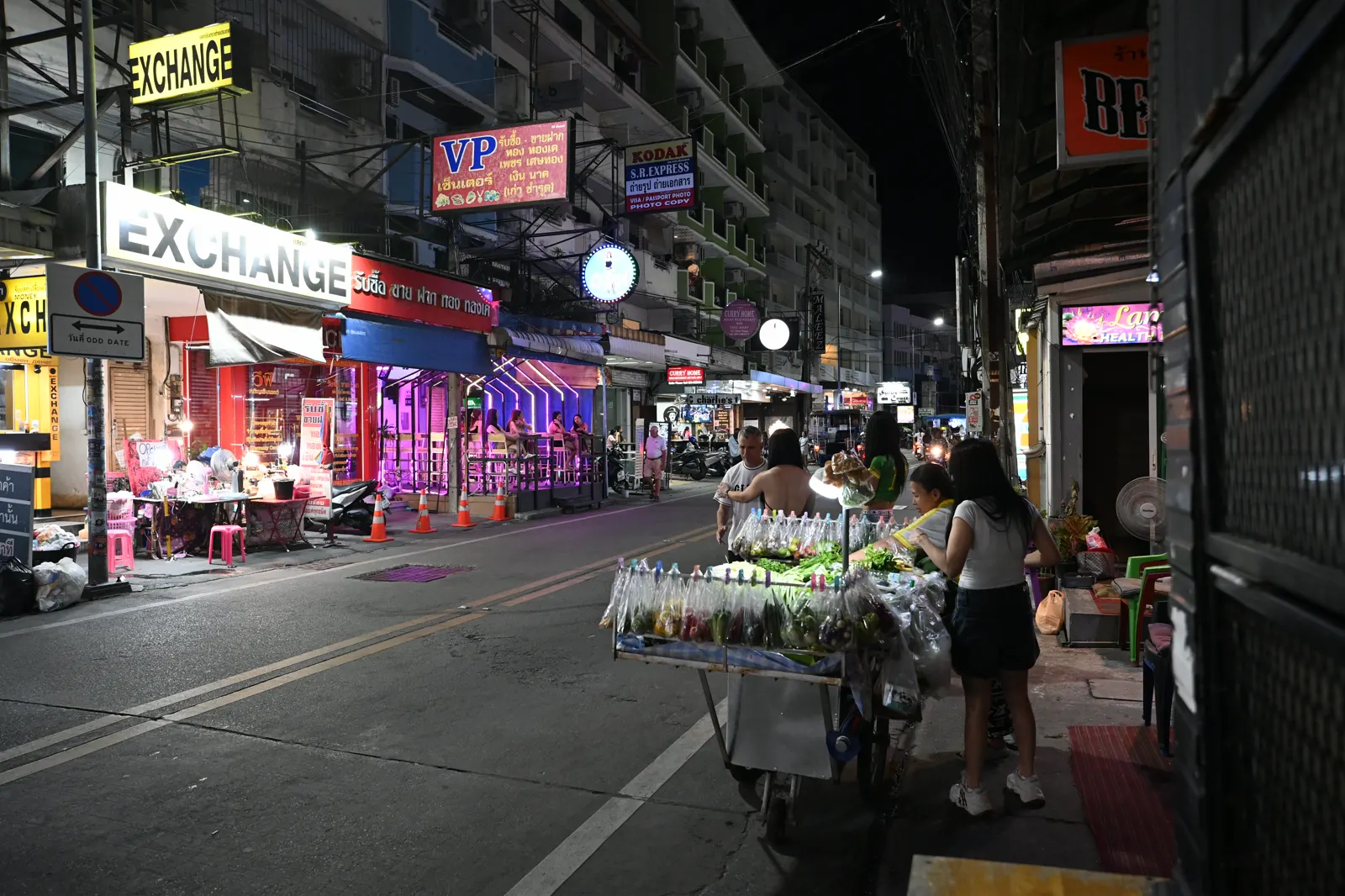 Currency exchange signs on a night street in Nong Pla Lai, Pattaya