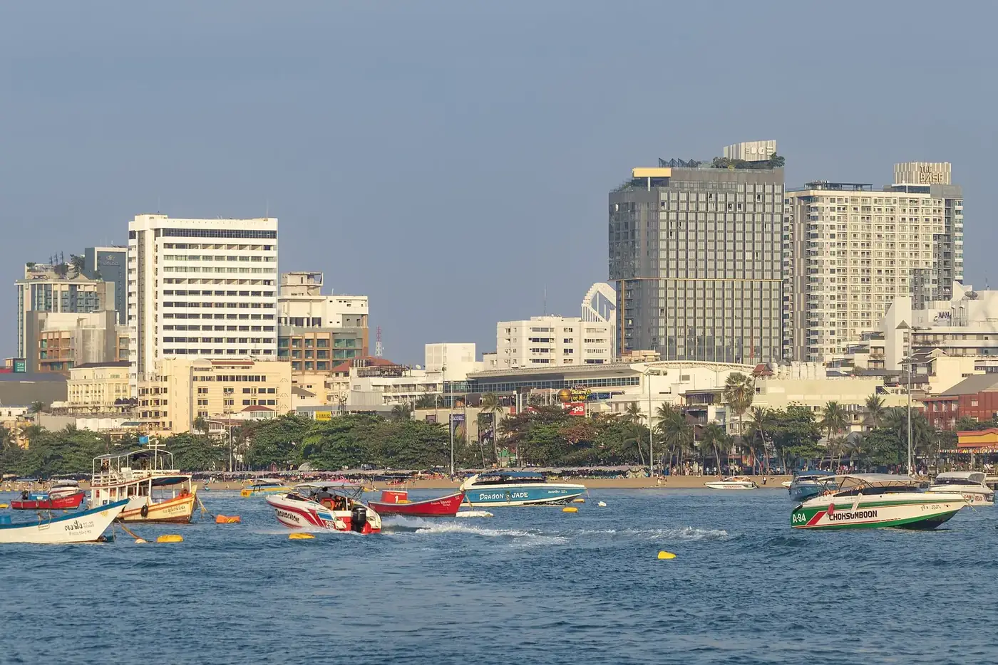 Pattaya's beachfront towers and the bay, seen from the water on a sunny morning