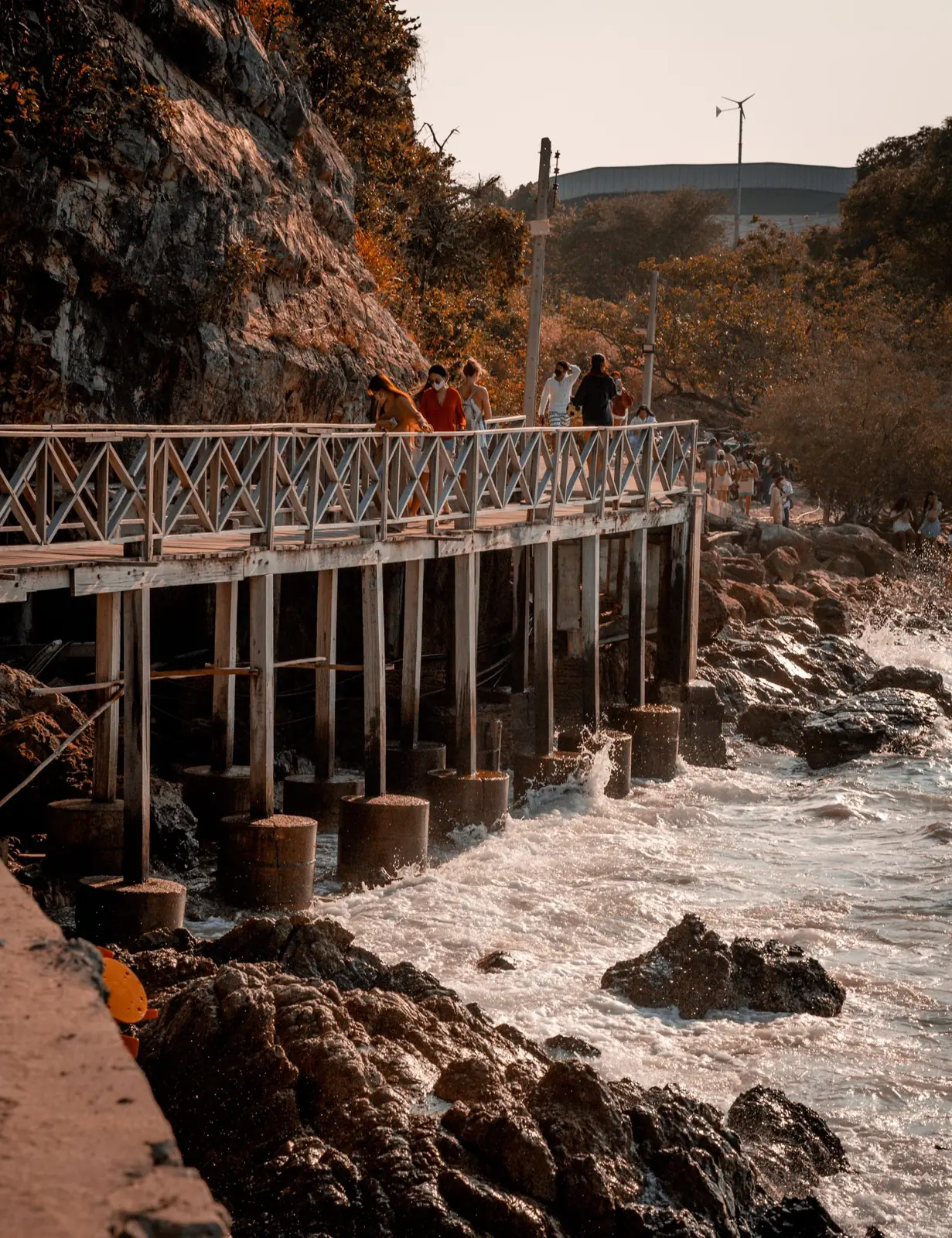 People and scooters on a coastal path above the sea at Ko Lan