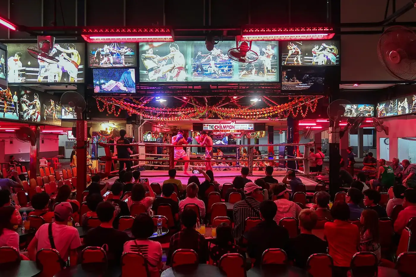 Crowds outside the bar fronts in the middle of Walking Street Pattaya at night