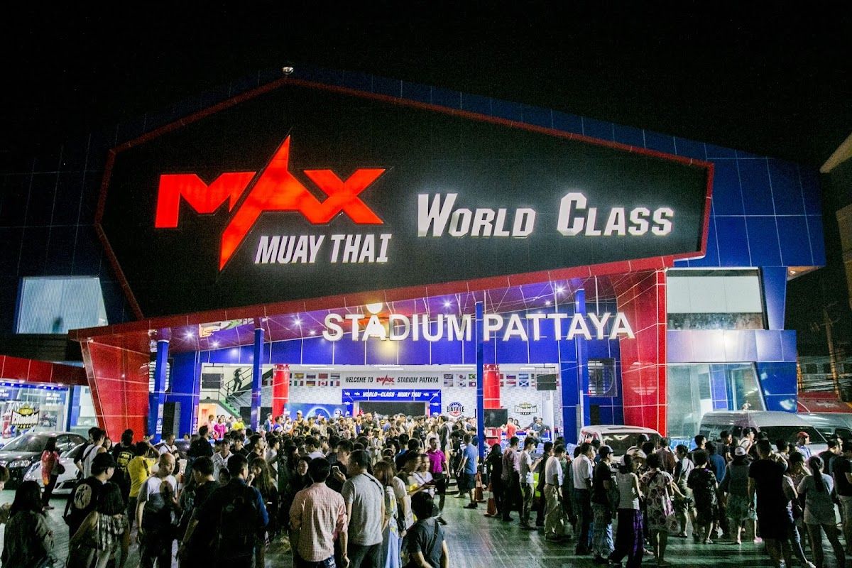 Muay Thai fighters in a Pattaya stadium, crowd watching under bright lights