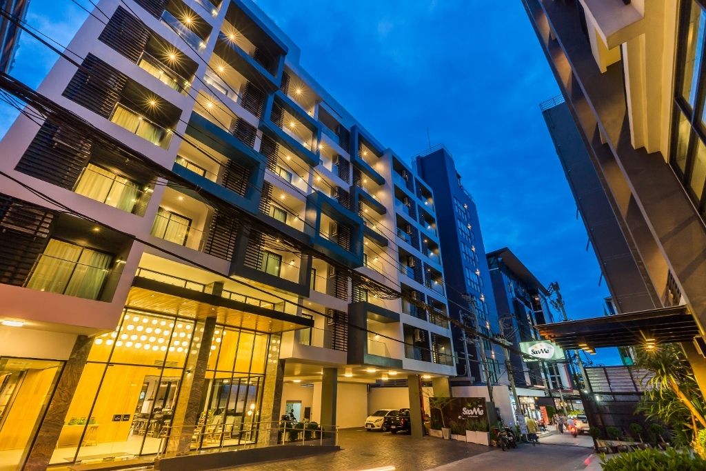 Sea Me Spring Tree Hotel in central Pattaya — a modern multi-storey hotel building lit up at dusk with the SeaMe sign at street level