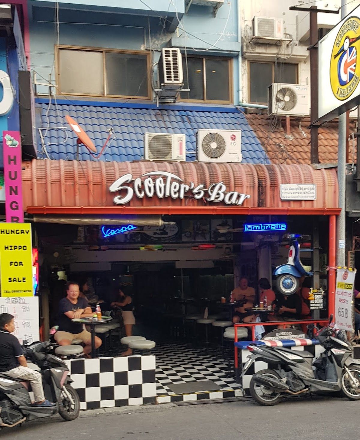 An open-air bar on Soi Buakhao, Pattaya, with customers at street-facing tables and a scooter-themed interior