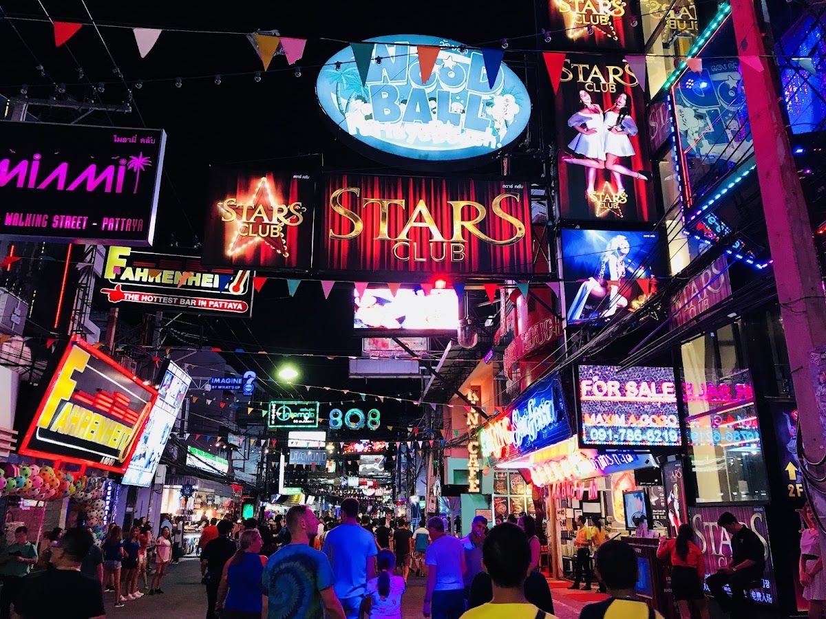 Walking Street Pattaya at night — neon signs including Stars Club and Fahrenheit bar, crowds of tourists moving through the entertainment strip