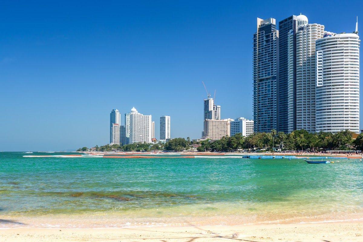 Wongamat Beach in north Pattaya — calm blue-green water backed by resort hotels and high-rise condominiums along the shore